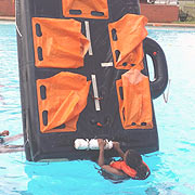 PST STUDENT DEMONSTRATING HOW TO TURN OVER THE LIFERAFT.